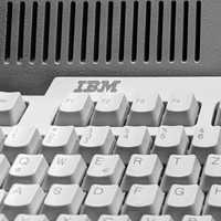 Close-up of an old IBM mechanical keyboard in black and white, with visible function keys and the IBM logo.